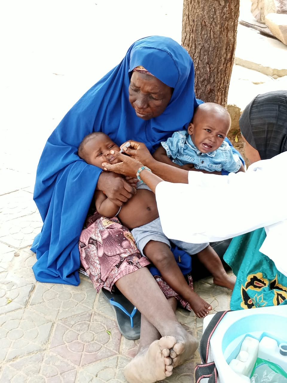 Mère tenant deux jeunes enfants pendant une vaccination