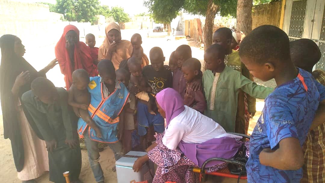 Enfants rassemblés autour d'une vaccinatrice lors d'une séance de vaccination dans un quartier au Niger